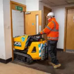 JCB HTD-5E electric dumpster driving through doorway.