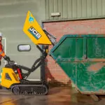 JCB HTD-5E electric dumpster dumping load into dumpster.