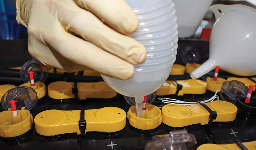 Technician watering a lead-acid battery.