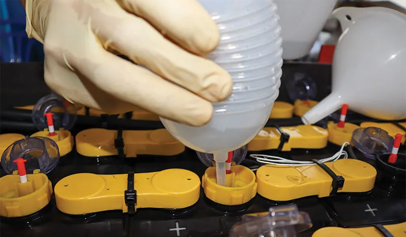 Technician watering a lead-acid battery.