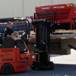 Bendi B40i5 forklift placing materials on truck trailer.