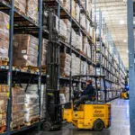 Bendi B40AC forklift in narrow warehouse aisle.