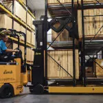 Bendi B40AC-DR electric forklift lifting pallet off warehouse racking.