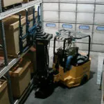 Bendi B55AC forklift placing pallet of materials on warehouse racking.