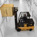 Drexel FL60AC-EX electric forklift placing pallet on warehouse racking.