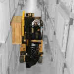 Drexel SL60AC electric forklift lifting pallet off warehouse shelving.