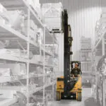 Drexel SL80AC forklift raising pallet off warehouse racking.