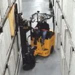 Bendi B30AC forklift placing items on warehouse shelf.