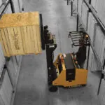 Landoll LSC30AC compact forklift lifting a pallet in a warehouse aisle.