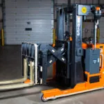 RICO EX stand-on reach truck, forks out.