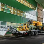 JCB AJ48D articulated boom lift stowed and on truck trailer.