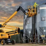 JCB AJ48D boom lift raised with maintenance worker.