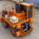 Rail King G7 mobile Railcar mover in parking lot.