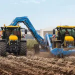 JCB 4220 Fastrac Icon agricultural tractors working side by side on farm.