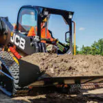 JCB 215T Compact Track Loader transporting bucket of dirt.