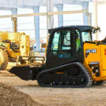 JCB 250T Compact Track Loader transporting bucket of materials on construction site.