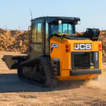JCB 250T Compact Track Loader driving on dirt terrain.