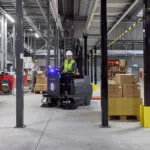 Nilfisk SW3000 ride-on sweeper cleaning logistics facility floors.
