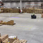 Nilfisk SW3000 rider sweeper cleaning large logistics facility's floors.