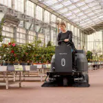 Nilfisk SW3000 sweeper cleaning floors in greenhouse.