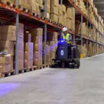 Nilfisk SW3000 rider sweeper professionally cleaning warehouse floor.