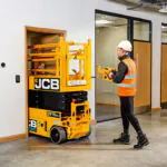 JCB S1932E compact forklift driving through doorway.